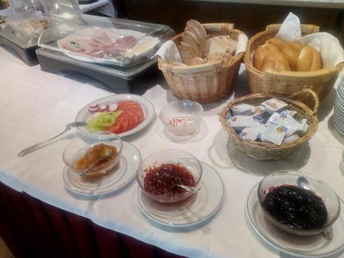 a table with bowls of food and baskets of bread at Hotel Restaurant zum Schwan in Schwanberg
