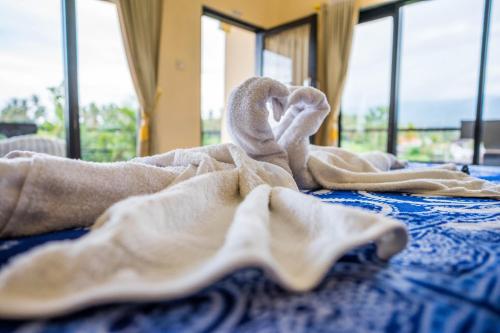 a pile of towels sitting on a bed at Summer Guesthouse Lovina in Lovina