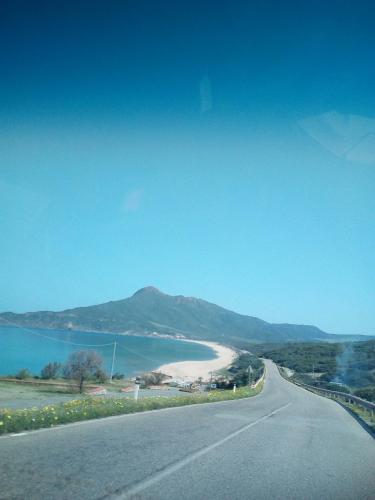 a road with a beach and a body of water at AL MARE, AL SOLE, SI', ma nella CASA DEL MINATORE in Buggerru