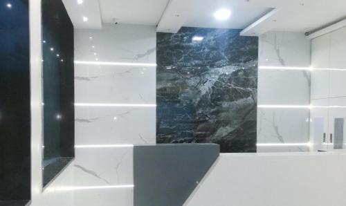 La salle de bains est pourvue d'un mur en marbre noir et blanc. dans l'établissement Treebo Trend Blue Moon Powai, à Mumbai