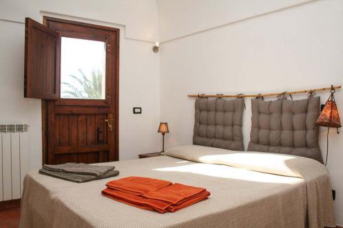 a bedroom with a bed with two towels on it at Dammuso Favarelle da Caty in Pantelleria