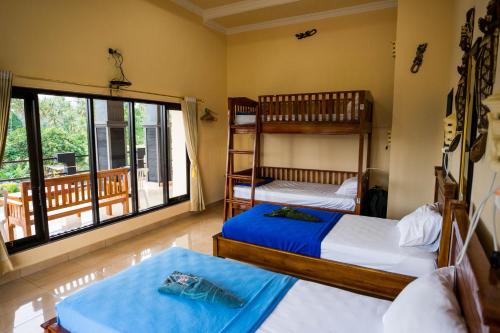 a bedroom with two bunk beds and a balcony at Summer Guesthouse Lovina in Lovina