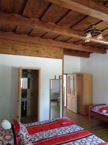 a bedroom with two beds and a ceiling with wooden beams at Gyöngyszemvendégház in Sátoraljaújhely