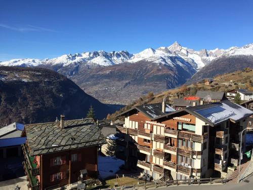 a building with snow capped mountains in the background at Hotel Restaurant Rothorn in Visperterminen