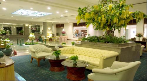 a hotel lobby with a couch and chairs and tables at Purimas Beach Hotel & Spa in Ban Chang