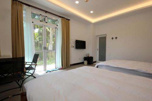 a bedroom with two beds and a large window at Song Yue Homestay in Yuchi