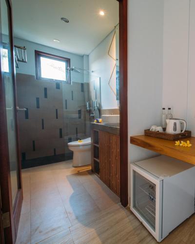 a bathroom with a shower and a sink and a toilet at Kaen Apartments in Canggu