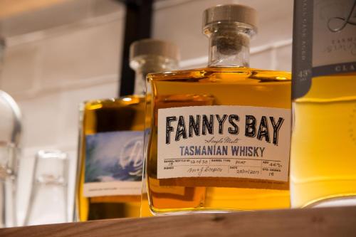 a bottle ofgins bay whisky sitting on a table at The Sebel Launceston in Launceston