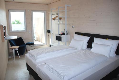 1 dormitorio con 1 cama grande con sábanas blancas en Schlafzimmer en Dinkelsbühl