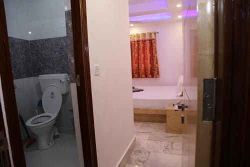 a bathroom with a toilet and a bath tub at Friends Hostel by Backpackers Heaven- New Delhi Railway Station - Paharganj in New Delhi