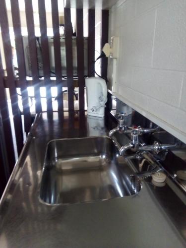 a stainless steel sink in a kitchen next to a counter at Redwood Lodge Motel in Levin