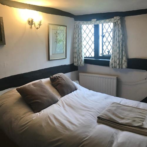 a bed with two pillows on it in a bedroom at Hurst Hill in Dunsfold