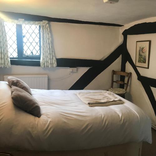 a bedroom with a large white bed and a window at Hurst Hill in Dunsfold