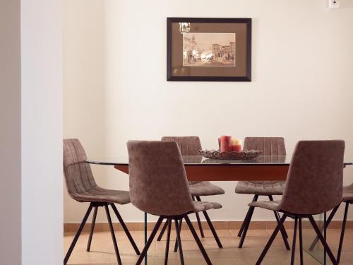 a dining room with a table and four chairs at Three Graces Holiday Houses Complex in Laganas