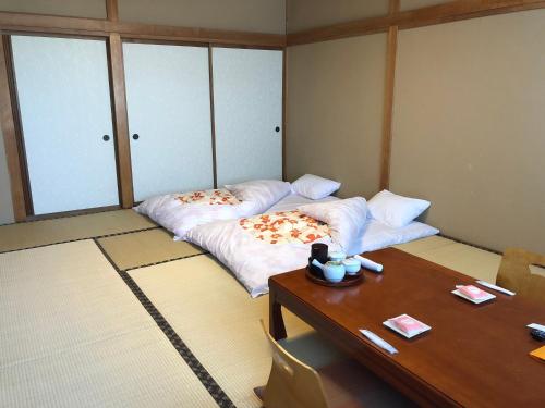 um quarto com uma cama e uma mesa em Taiheikan em Fujikawaguchiko