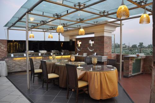 a restaurant with tables and chairs on a patio at Crystal Inn in Agra