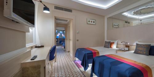 a hotel room with two beds and a tv at Granada Luxury Belek - Family Kids Concept in Belek