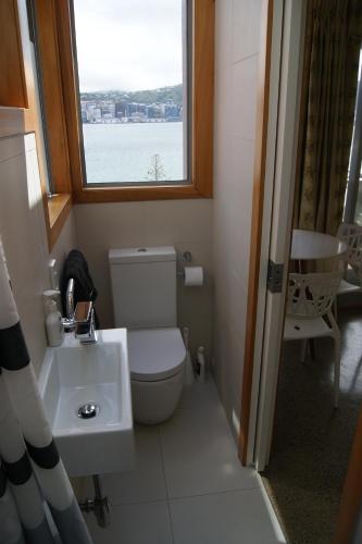 a bathroom with a toilet and a sink and a window at Oriental Bay At Its Best in Wellington