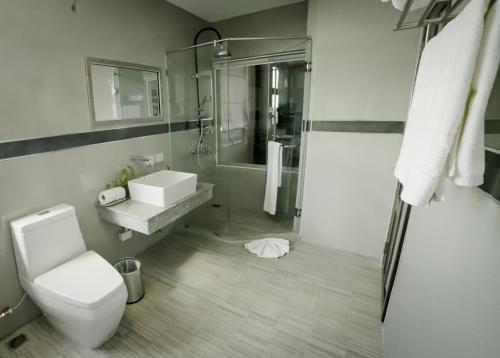 a bathroom with a toilet and a sink and a shower at Gallery Design - SHA Extra Plus in Si Sa Ket