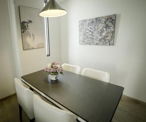 a dining room table with a vase of flowers on it at Gallery Design - SHA Extra Plus in Si Sa Ket