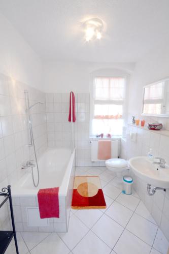 a white bathroom with a tub and a sink at Elbidylle in Königstein an der Elbe