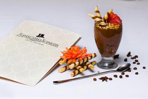 a drink with cinnamon sticks and a card next to a table at Aristokrat in Vinnytsya