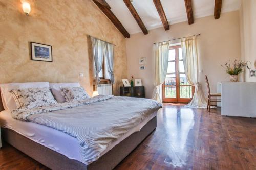sypialnia z dużym łóżkiem i drewnianą podłogą w obiekcie Villa Marinac w Poreču