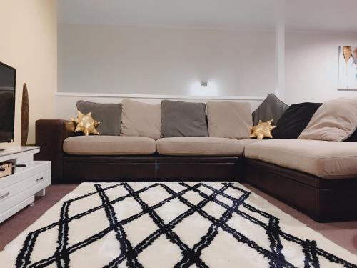 a living room with a couch and a television at The Heart of Rotorua in Rotorua