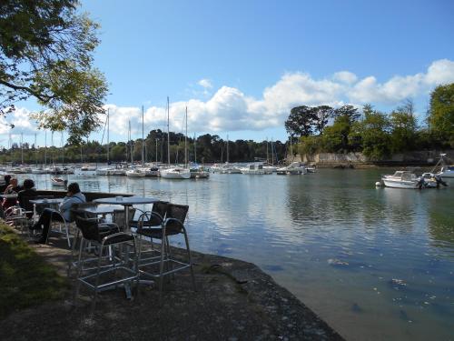 Ein paar Leute sitzen am Tisch am Wasser. in der Unterkunft maison individuelle mr Alaphilippe in Vannes