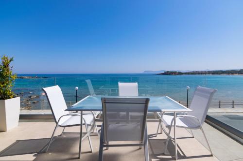 a table and chairs with a view of the ocean at Sonja Beachfront Apartments in Kato Daratso