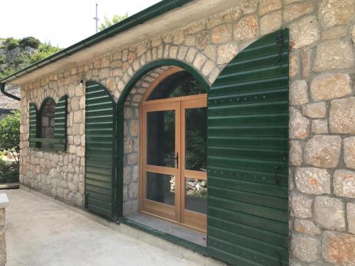 an entry to a stone building with a wooden door at River huts Zrmanja in Obrovac