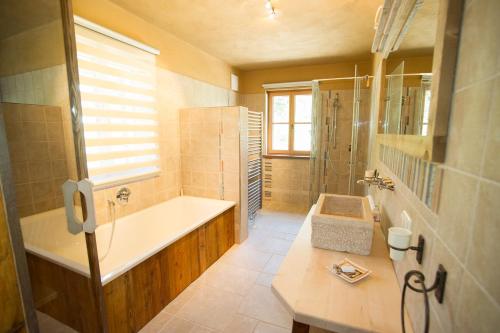 ein großes Bad mit einer Badewanne und einem Waschbecken in der Unterkunft Chalet Altaussee in Altaussee