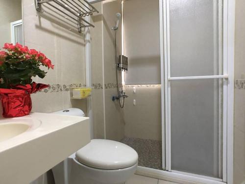 uma casa de banho com um chuveiro, um WC e um lavatório. em Laughter House II em Yilan City