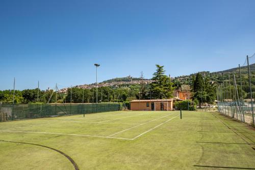 a tennis court with a tennis court at Giotto Country House & Spa in Assisi