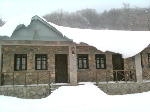 a house covered in snow with a pile of snow at Manis Hotel in Nimfaíon