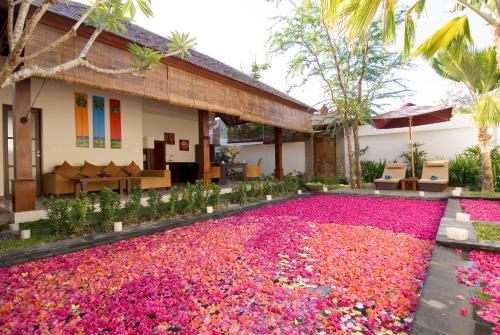 a large pool of pink flowers in front of a house at Ellora Villa in Sanur
