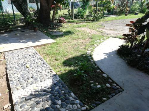 a garden with rocks and a tree and a path at Coco Country Homes in Melaka