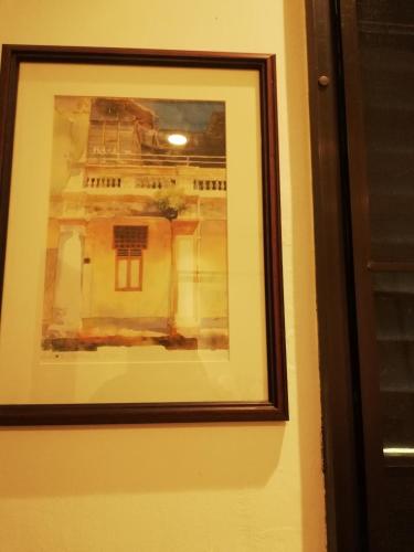 a framed picture of a building on a wall at Coco Country Homes in Melaka