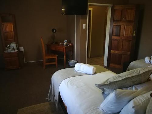 a hotel room with two beds and a desk at Augrabies Falls Lodge & Camp in Augrabies