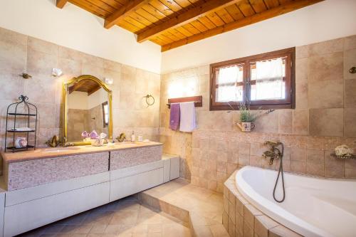 a large bathroom with a tub and a sink at Sunny Countryside Villa - With private pool in Faliraki