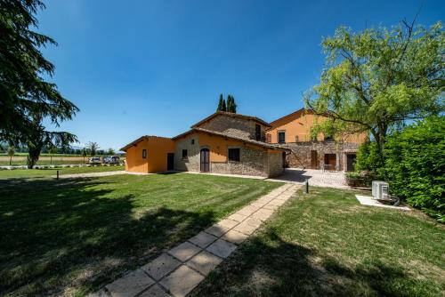 an old stone house with a grass yard at Giotto Country House & Spa in Assisi