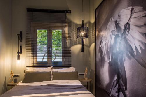 a bedroom with a bed with a large painting on the wall at Gambello Luxury Rooms in Nafplio