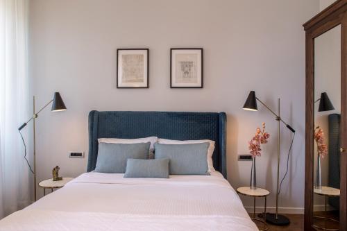 a bedroom with a large bed with two lamps at Gambello Luxury Rooms in Nafplio