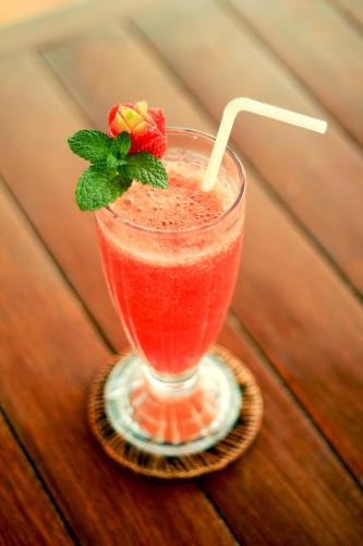 a drink on a coaster with a strawberry on top at The Garuda Villa and Restaurant in Bedugul