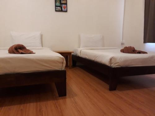 two beds in a room with wooden floors at Laos Haven Hotel in Vang Vieng
