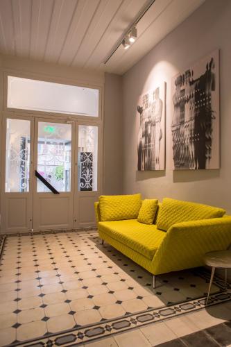 a yellow couch in a living room with a window at Gambello Luxury Rooms in Nafplio