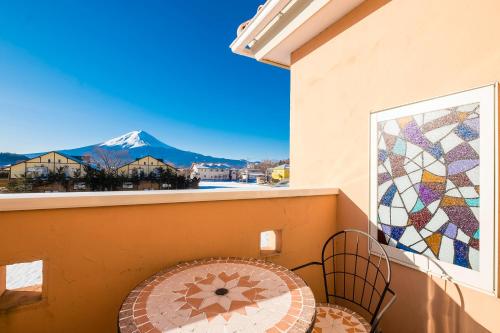 a balcony with a table and a view of a mountain at Villa Ensoleille in Fujikawaguchiko