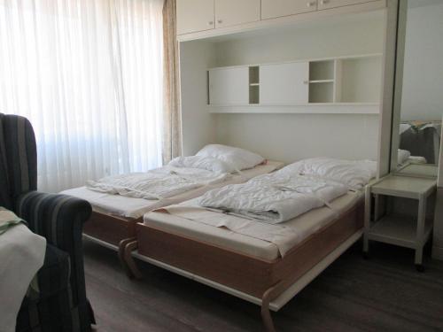 - 2 lits jumeaux dans une chambre avec miroir dans l'établissement Einzimmerappartement-fuer-zwei-Personen, à Westerland
