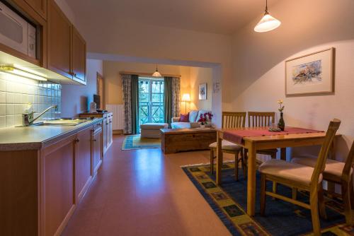a kitchen and living room with a table and a couch at Ferienwohnungen Hotel Garni Dörflerwirt in Aflenz Kurort