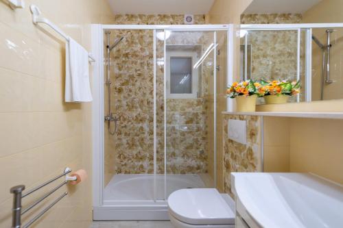 a bathroom with a shower and a toilet and a sink at Green Paradise Apartments in Mokošica